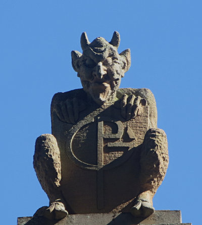 The gargoyles hold shields inscribed with 'GP' (Government Printery).